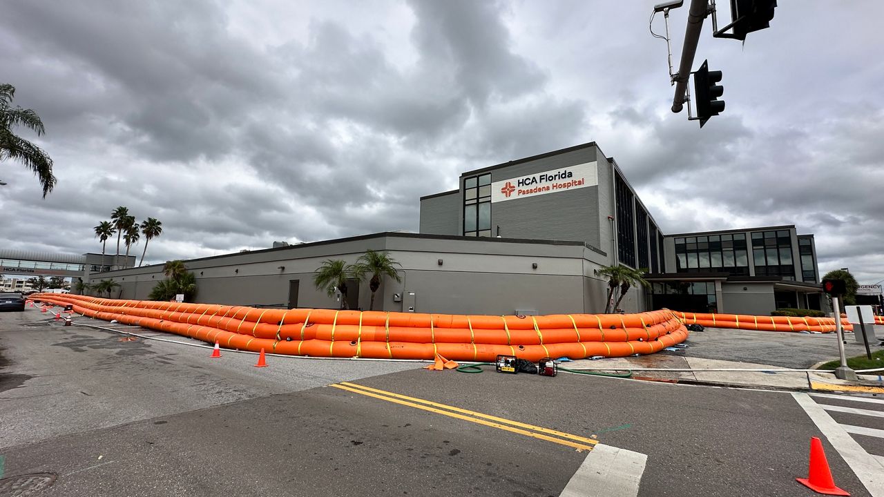Orange Tiger Dam barrier deployed around a commercial facility, from the supplied presentation